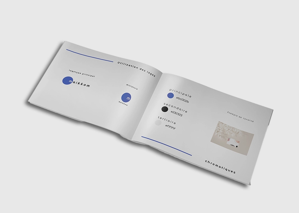 Charte graphique Maikkom – Documentation technique et standards visuels | Agence communication Maikkom charte graphique - Livret documentation technique ouvert montrant codes couleurs et spécifications visuelles